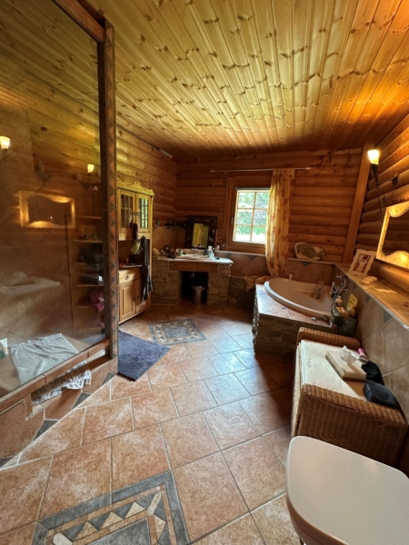 Blick in das Badezimmer mit großer Dusche und Eckbadewanne im Mediteranen Stil