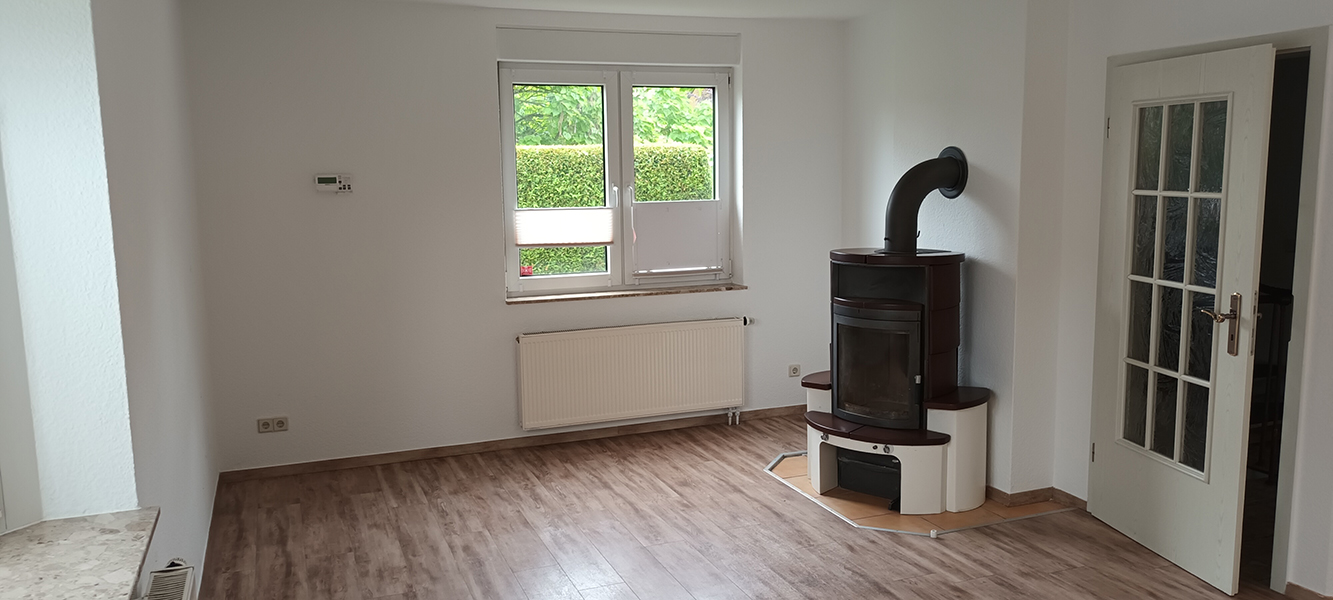 Wohnzimmer mit Kaminofen, Fensterfront und Holzboden im Einfamilienhaus in Nordhausen