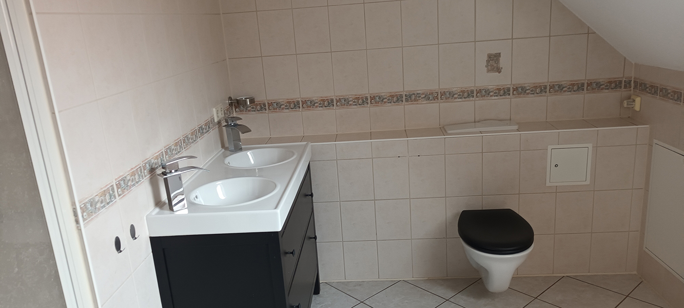 Gefliestes Badezimmer im Obergeschoss mit Doppelwaschbecken und WC im Einfamilienhaus in Nordhausen.