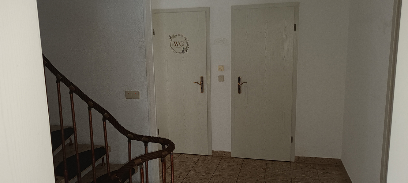 Flur im Untergeschoss mit Treppe und zwei Zimmertüren im Einfamilienhaus in Nordhausen