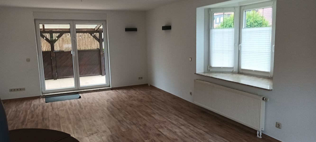 Helles Wohnzimmer mit großen Fenstern, Terrasse und Holzoptik-Boden im Einfamilienhaus in Nordhausen