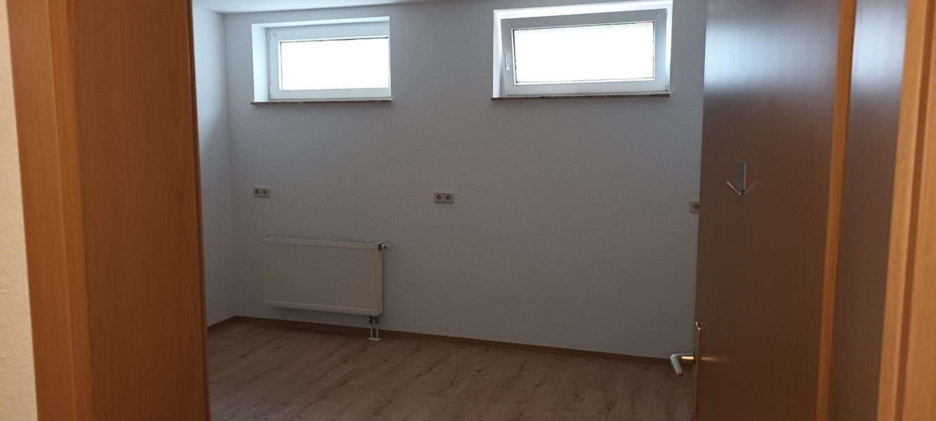 Helles Kellerzimmer mit zwei Fenstern und Heizkörper im Einfamilienhaus in Nordhausen
